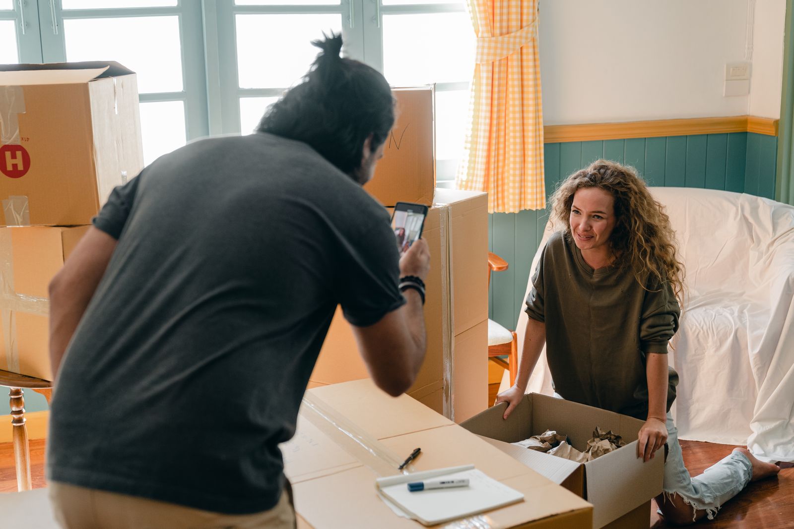 Someone photographing moving boxes with a phone to request a quote